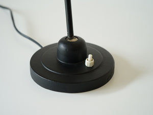 ドイツデザインの黒いテーブルランプの土台にあるスイッチとアームの角度調整