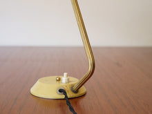 画像をギャラリービューアに読み込む, デンマークデザインの黄色いテーブルランプの金色のアームの曲線

