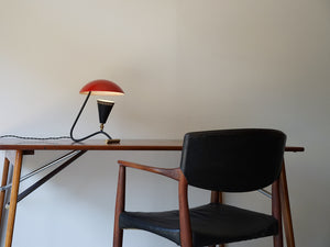 テーブルの上の赤いシェードのテーブルランプと椅子
